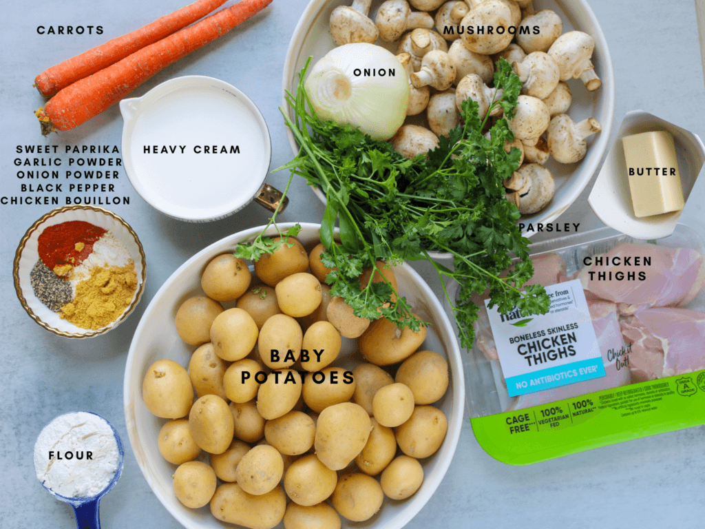 Ingredients for creamy mushroom chicken with potatoes including baby potatoes, chicken thighs, mushrooms, onion, carrots, heavy cream, butter, flour, parsley, sweet paprika, garlic powder, onion powder, chicken bouillon, salt, and black pepper.